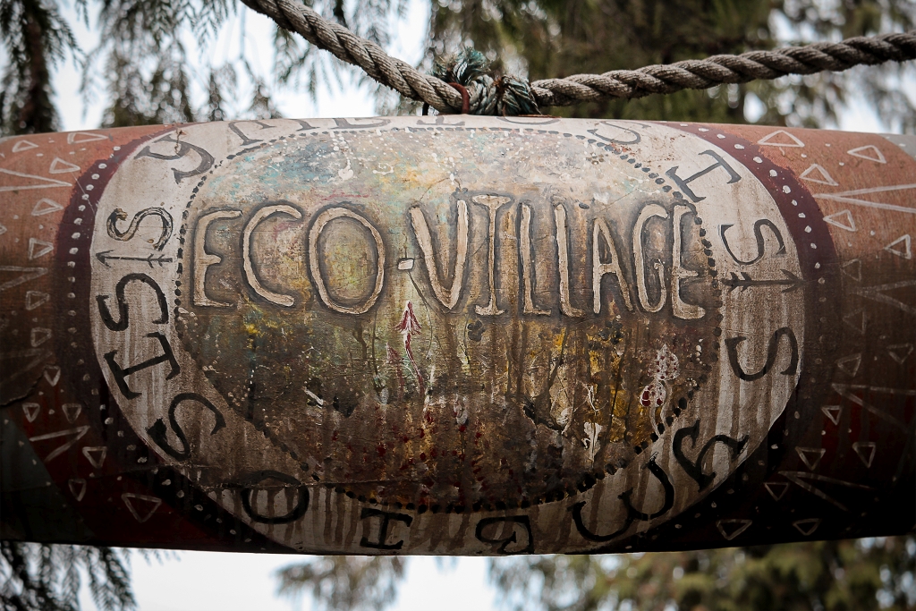 Nápis eco-village u vstupu do hippies vesničky.